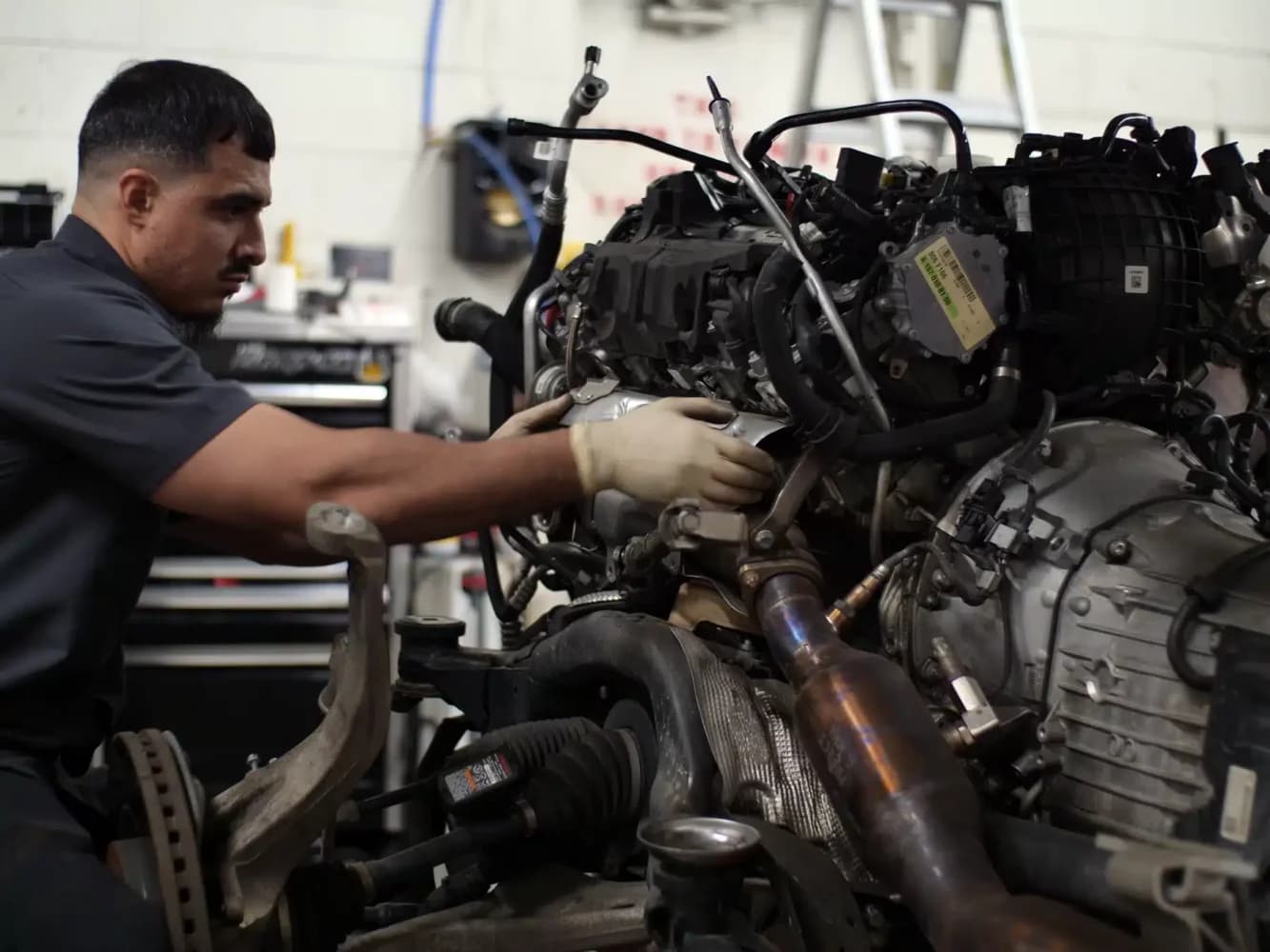 Technician working on engine in Evoke Autowerks shop in Englewood, CO.